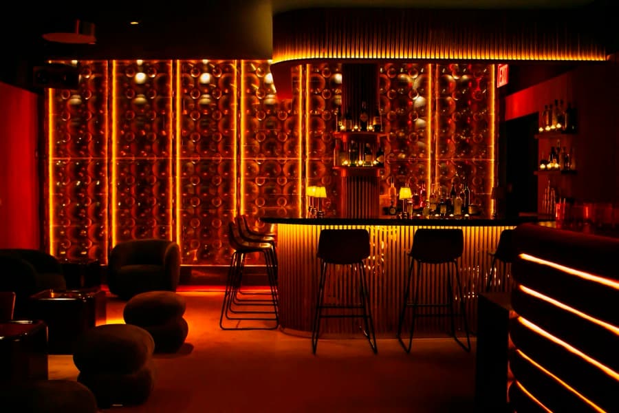 The red-lit underground bar at Music For A While, stools pulled up to the counter